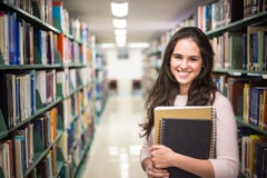 In the library - pretty female student with books working in a h royalty free stock image In the library - pretty female student with books working in a h royalty free stock image