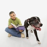 Libro de lectura del muchacho con el perro. foto de archivo Libro de lectura del muchacho con el perro. foto de archivo