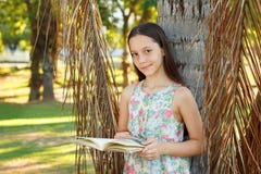 Libro di lettura teenager sorridente sveglio della ragazza fotografia stock Libro di lettura teenager sorridente sveglio della ragazza fotografia stock