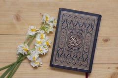 Libro y narcisos santos del Quran en el fondo de madera ramadan Libro y narcisos santos del Quran en el fondo de madera ramadan