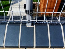 Licht geschilderde staalomheining en post met grasrijke tuinachtergrond stock fotografie Licht geschilderde staalomheining en post met grasrijke tuinachtergrond stock fotografie