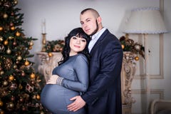Liebende Familie, Ehemann und Frau in der Halle mit Weihnachtsbaum und Kamin lizenzfreies stockbild Liebende Familie, Ehemann und Frau in der Halle mit Weihnachtsbaum und Kamin lizenzfreies stockbild