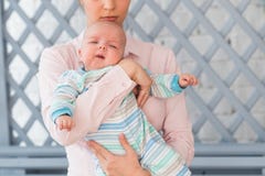 Liebevolle junge Mutter, die zuhause ihren Sohn hält lizenzfreies stockbild Liebevolle junge Mutter, die zuhause ihren Sohn hält lizenzfreies stockbild