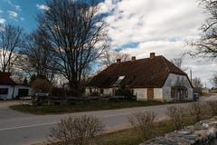 LIEPUPE, LETTONIA - 13 APRILE 2019: Vecchia casa medievale Jasmini in bello tempo soleggiato della primavera con cielo blu e le n immagine stock libera da diritti LIEPUPE, LETTONIA - 13 APRILE 2019: Vecchia casa medievale Jasmini in bello tempo soleggiato della primavera con cielo blu e le n immagine stock libera da diritti