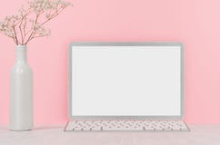 Lieu de travail à la maison élégant avec le carnet vide argenté élégant d'ordinateur et les fleurs blanches dans le vase sur le f images libres de droits Lieu de travail à la maison élégant avec le carnet vide argenté élégant d'ordinateur et les fleurs blanches dans le vase sur le f images libres de droits