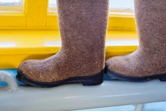 Lifehack pour sécher des chaussures Les bottes senties sont sur une batterie chaude, caloduc dans la maison de village images stock Lifehack pour sécher des chaussures Les bottes senties sont sur une batterie chaude, caloduc dans la maison de village images stock