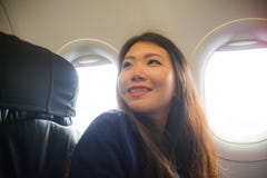 Lifestyle candid portrait of young happy and beautiful Asian Chinese woman traveling for holidays inside airplane cabin excited on stock images Lifestyle candid portrait of young happy and beautiful Asian Chinese woman traveling for holidays inside airplane cabin excited on stock images