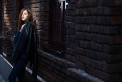 Lifestyle fashion portrait of brunette girl in rock black style, standing outdoors in the city street stock photos Lifestyle fashion portrait of brunette girl in rock black style, standing outdoors in the city street stock photos