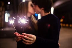 Lifestyle portrait of couple in love holding sparkling New Year fireworks on the city streets with lot of lights on background. Stock Photography Lifestyle portrait of couple in love holding sparkling New Year fireworks on the city streets with lot of lights on background. Stock Photography
