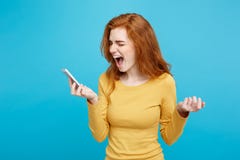 Lifestyle and Technology concept - Portrait of ginger red hair girl shouting on the phone. Isolated on Blue Pastel royalty free stock images Lifestyle and Technology concept - Portrait of ginger red hair girl shouting on the phone. Isolated on Blue Pastel royalty free stock images