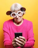 Lifestyle, tehnology and people concept: Elderly lady holding a smartphone stock images Lifestyle, tehnology and people concept: Elderly lady holding a smartphone stock images