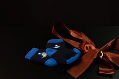 Liggen de baby blauwe sokken met een boog op een zwarte lijst, aangaande een zwarte achtergrond royalty-vrije stock fotografie Liggen de baby blauwe sokken met een boog op een zwarte lijst, aangaande een zwarte achtergrond royalty-vrije stock fotografie