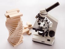 A light microscope for studying microbiology and pharmacology is located in the laboratory next to the DNA model on a light backgr stock photography A light microscope for studying microbiology and pharmacology is located in the laboratory next to the DNA model on a light backgr stock photography