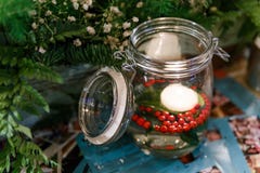Lighted Candle in The Glass Jar with White Flowers and Green Leaves Stock Image Lighted Candle in The Glass Jar with White Flowers and Green Leaves Stock Image