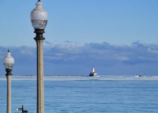 Lightpost i förgrund med cloudscape över horisont av Lake Michigan på en frysa Januari morgon med den djupfrysta sjön arkivbild Lightpost i förgrund med cloudscape över horisont av Lake Michigan på en frysa Januari morgon med den djupfrysta sjön arkivbild