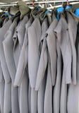 Ligne des Wetsuits accrochants multiples photos stock Ligne des Wetsuits accrochants multiples photos stock