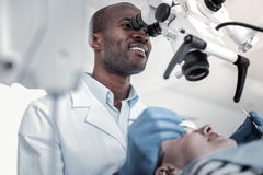 Positive delighted international dentist examining his patient stock image Positive delighted international dentist examining his patient stock image