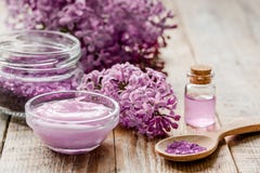 Lila skönhetsmedel med blommor och brunnsorten ställde in på trätabellbakgrund royaltyfri foto Lila skönhetsmedel med blommor och brunnsorten ställde in på trätabellbakgrund royaltyfri foto