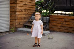 Lilla flickan med en iklädd gullig rosa färg för allvarlig blick klär Royaltyfria Foton Lilla flickan med en iklädd gullig rosa färg för allvarlig blick klär Royaltyfria Foton