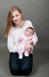 Lilla flickan som rymmer ett nyfött, behandla som ett barn arkivfoton Lilla flickan som rymmer ett nyfött, behandla som ett barn arkivfoton