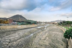 Lima/Peru - 07 18 2017: Trockene und schmutzige Unterseite des Rimac-Flusses herein in die Stadt lizenzfreie stockfotografie Lima/Peru - 07 18 2017: Trockene und schmutzige Unterseite des Rimac-Flusses herein in die Stadt lizenzfreie stockfotografie