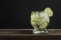 Limonade fraîche froide avec le concombre, la glace et les feuilles en bon état au-dessus de la table en bois et du fond noir Boi photographie stock libre de droits Limonade fraîche froide avec le concombre, la glace et les feuilles en bon état au-dessus de la table en bois et du fond noir Boi photographie stock libre de droits