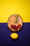 Limón con frutos secos en un amarillo y un fondo púrpura imagenes de archivo Limón con frutos secos en un amarillo y un fondo púrpura imagenes de archivo