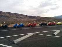 Line of two-seat scooter cars in parking lot with mountain landscape stock photo Line of two-seat scooter cars in parking lot with mountain landscape stock photo