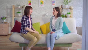 Linguagem gestual surda bonita de dois usos das jovens mulheres na sala de visitas vídeos de arquivo Linguagem gestual surda bonita de dois usos das jovens mulheres na sala de visitas vídeos de arquivo