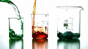 Liquidi chimici che versano nel becher Liquidi chimici che versano nel becher