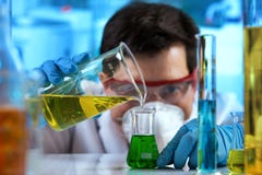 Liquidi mescolantesi di lavoro del ricercatore nel laboratorio di biochimica fotografia stock Liquidi mescolantesi di lavoro del ricercatore nel laboratorio di biochimica fotografia stock