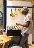 LISBOA, PORTUGAL - 17 DE ABRIL DE 2019: El cocinero prepara los pasteles portugueses tradicionales Pastel de Nata en Lisboa imagen de archivo libre de regalías LISBOA, PORTUGAL - 17 DE ABRIL DE 2019: El cocinero prepara los pasteles portugueses tradicionales Pastel de Nata en Lisboa imagen de archivo libre de regalías