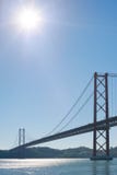 Lissabon 25 april-hangbrug againt blauwe hemel en zon Royalty-vrije Stock Foto