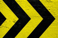 Listras amarelas e pretas do sinal de advertência do perigo como as setas pintadas sobre o cimento concreto muram como o fundo da imagem de stock Listras amarelas e pretas do sinal de advertência do perigo como as setas pintadas sobre o cimento concreto muram como o fundo da imagem de stock