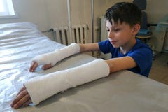 Lite att n?rma sig pojken efter ett st?ngt brott sjukhuset f?r medicinsk hj?lp i form av en samkopiering av murbruk f?rbinder royaltyfri fotografi Lite att n?rma sig pojken efter ett st?ngt brott sjukhuset f?r medicinsk hj?lp i form av en samkopiering av murbruk f?rbinder royaltyfri fotografi
