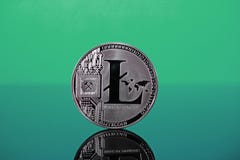 Litecoin crypto currency coin on reflective colorful background Stock Images Litecoin crypto currency coin on reflective colorful background Stock Images
