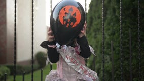 Liten flicka i prinsessan Costume Holding en svart ballong Hon ser j?tteglad, d?rf?r att idagen ?r allhelgonaaftonferie arkivfilmer Liten flicka i prinsessan Costume Holding en svart ballong Hon ser j?tteglad, d?rf?r att idagen ?r allhelgonaaftonferie arkivfilmer