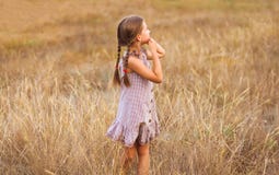 Liten flicka på ett vetefält med hennes holded händer royaltyfri foto Liten flicka på ett vetefält med hennes holded händer royaltyfri foto