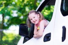 Liten flickasammanträde i den vita bilen arkivfoto Liten flickasammanträde i den vita bilen arkivfoto