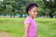 Liten lycklig och glad afrikansk amerikanflicka som spelar i parkera royaltyfria foton Liten lycklig och glad afrikansk amerikanflicka som spelar i parkera royaltyfria foton