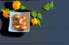 Liten maträtt med guld- chokladpåskägg och mörk träbakgrund royaltyfri foto Liten maträtt med guld- chokladpåskägg och mörk träbakgrund royaltyfri foto