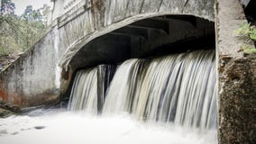 Liten vattenfall som flödar från en samllfördämning fotografering för bildbyråer Liten vattenfall som flödar från en samllfördämning fotografering för bildbyråer