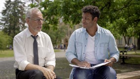 Literature teacher giving advice to Hispanic student about essay writing stock image Literature teacher giving advice to Hispanic student about essay writing stock image