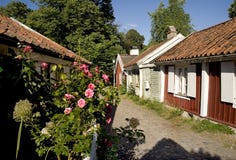 Litet rött och med hus med rosa rosor royaltyfria bilder Litet rött och med hus med rosa rosor royaltyfria bilder