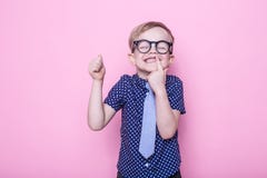 Little adorable boy in tie and glasses. School. Preschool. Fashion. Studio portrait over pink background stock images Little adorable boy in tie and glasses. School. Preschool. Fashion. Studio portrait over pink background stock images