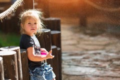 Little girl playing and having fun enjoying the spray of the fountain stock photos Little girl playing and having fun enjoying the spray of the fountain stock photos