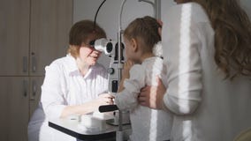 Little adorable girl in child`s ophthalmology - optometrist checking eyesight stock photos Little adorable girl in child`s ophthalmology - optometrist checking eyesight stock photos