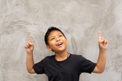 Little asian boy smiling with finger pointing upward. royalty free stock photo Little asian boy smiling with finger pointing upward. royalty free stock photo