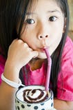 Little Asian Girl Enjoy A Cup Of Chocolate Shake. Royalty Free Stock Images