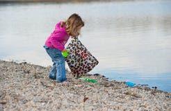 Little Baby Girl Cleaning The Beach Royalty Free Stock Image Little Baby Girl Cleaning The Beach Royalty Free Stock Image